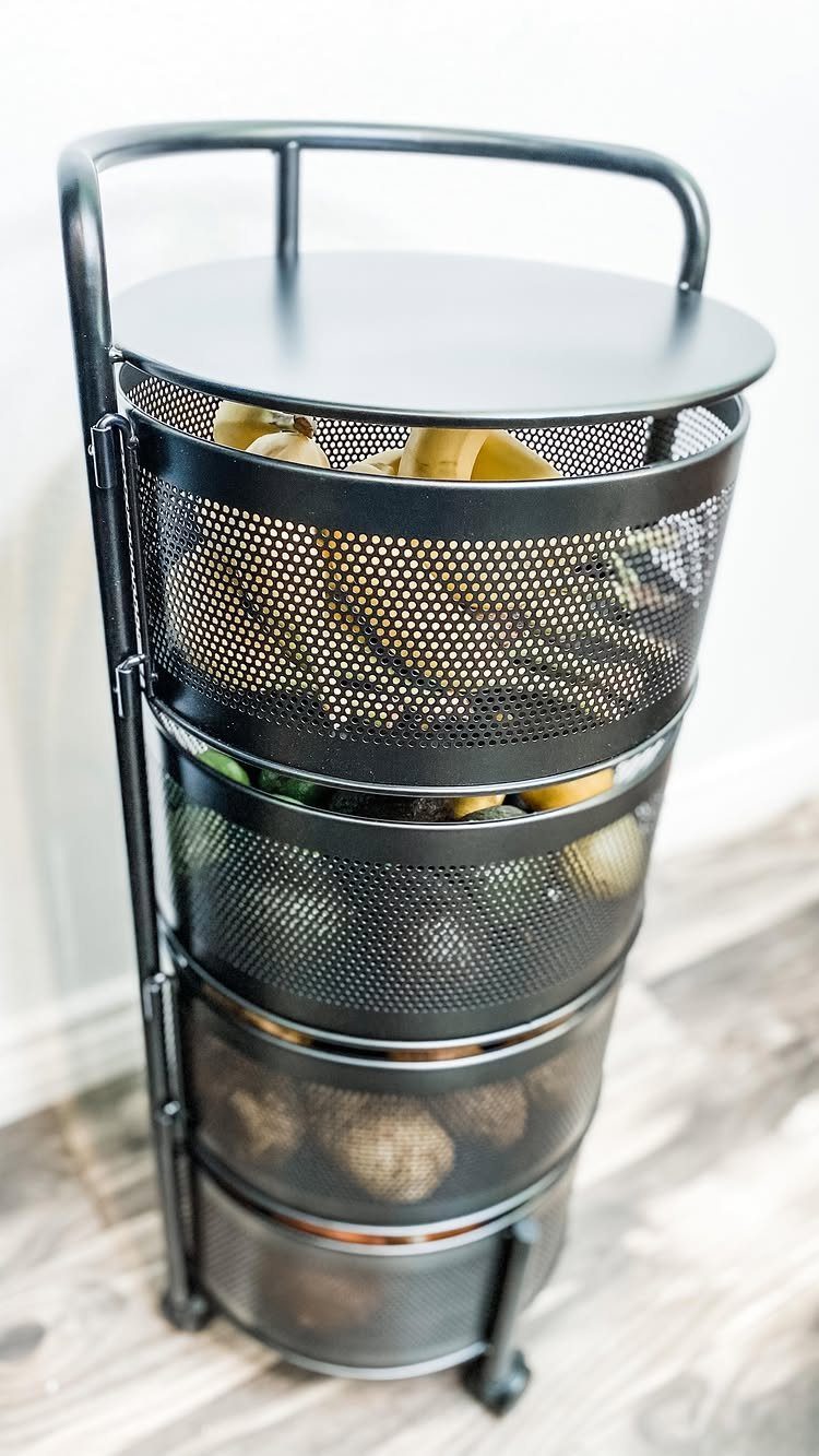 32 Simply Kitchen Design Ideas for a Clean, Modern Space 33 Black metal mesh tiered storage basket filled with potatoes and bananas on wood floor.