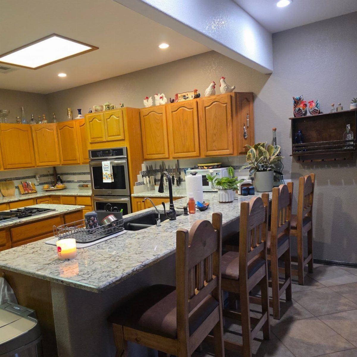 Wooden kitchen cabinets with decorative figurines stored on the top surface above the doors.