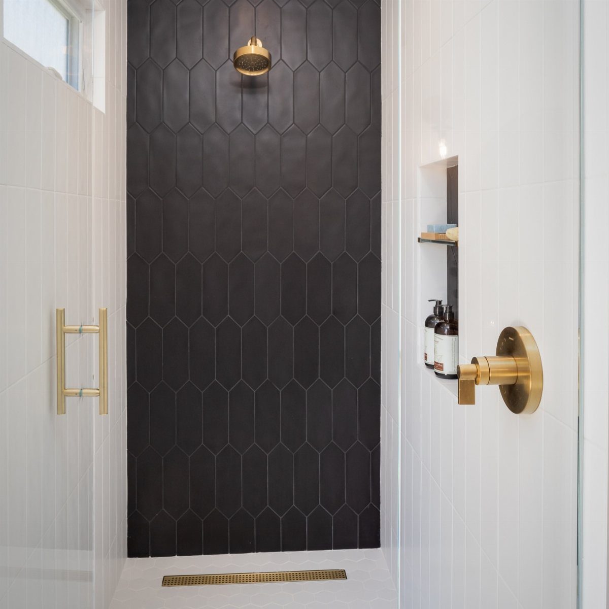 Black Mosaic Tile Bathroom: 14 Designs from Hex to Herringbone 5 Black picket tile shower wall with gold fixtures and white surrounding tiles.