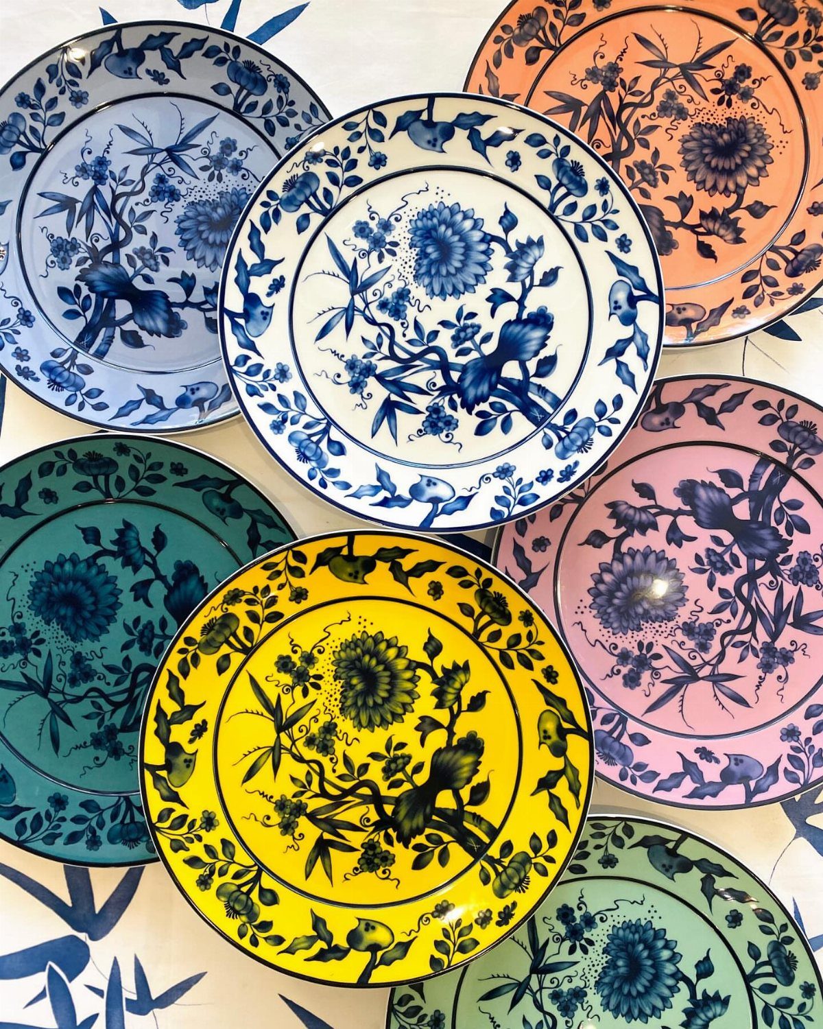 Fine China Plates in 11 Classic and Modern Styles 7 Colorful porcelain plates with blue floral patterns in yellow, pink, teal, and orange.