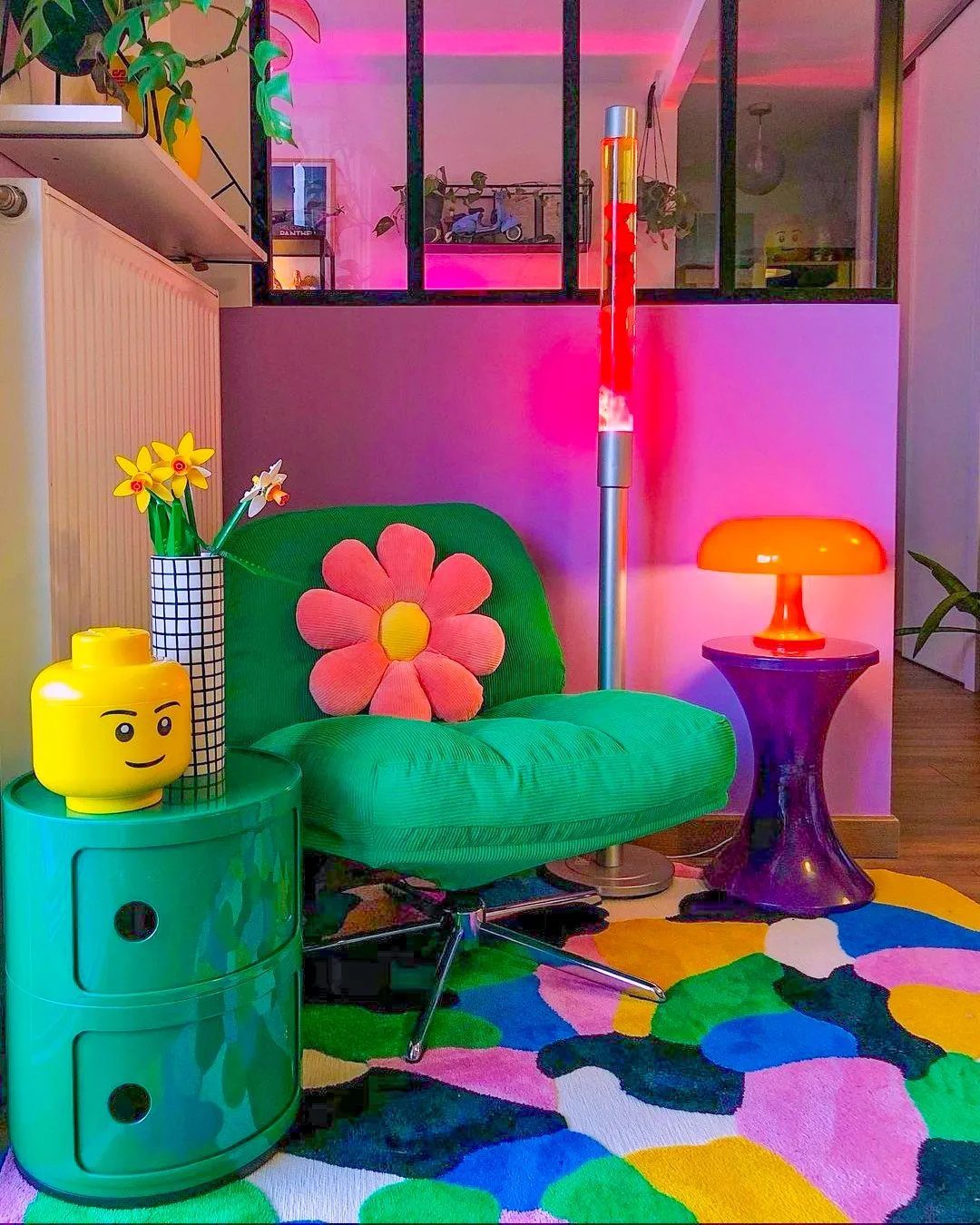 27 Vibey Living Room Aesthetic Ideas Worth Copying 17 Green swivel chair with flower pillow in a colorful room with pink walls.