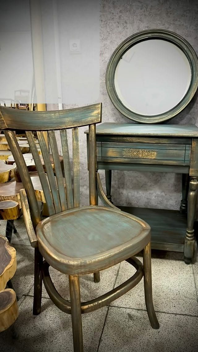 Distressed teal and gold wooden chair next to a matching table and mirror.