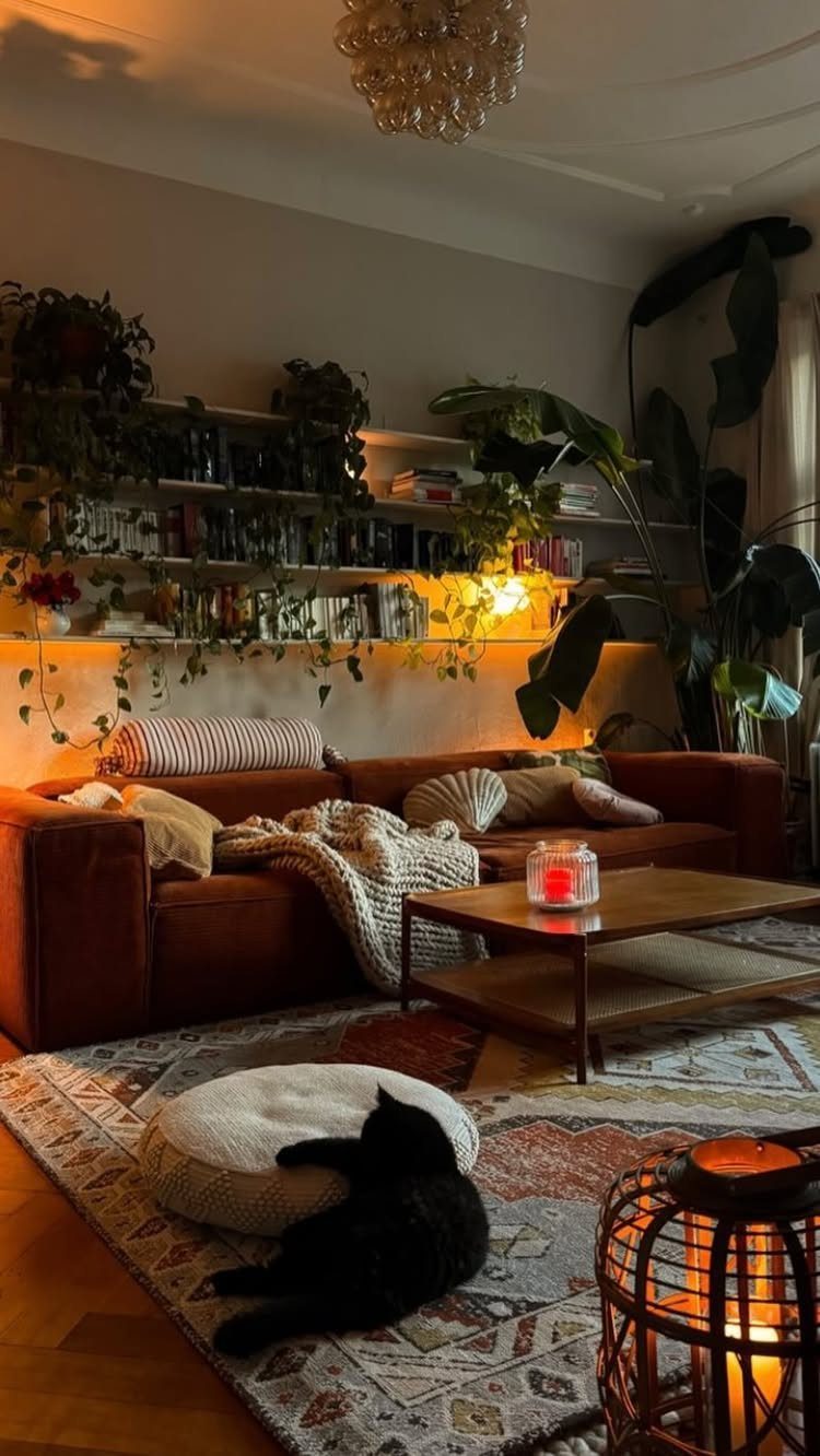 27 Vibey Living Room Aesthetic Ideas Worth Copying 4 Cozy living room with brown leather sofa and white floating shelves filled with plants.