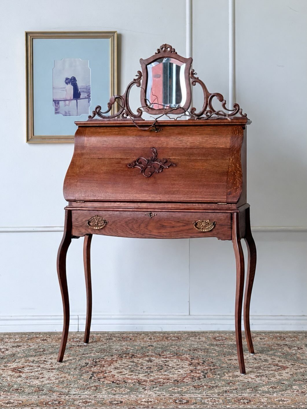 Vintage French carved oak secretary desk with roll-top and ornate mirror on top.