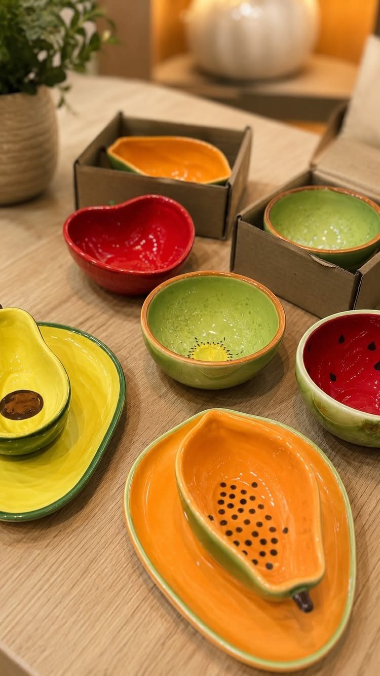 Fruit Shaped Plates in 12 Styles 11 Fruit shaped ceramic plates and bowls in vibrant colors on a wooden table.