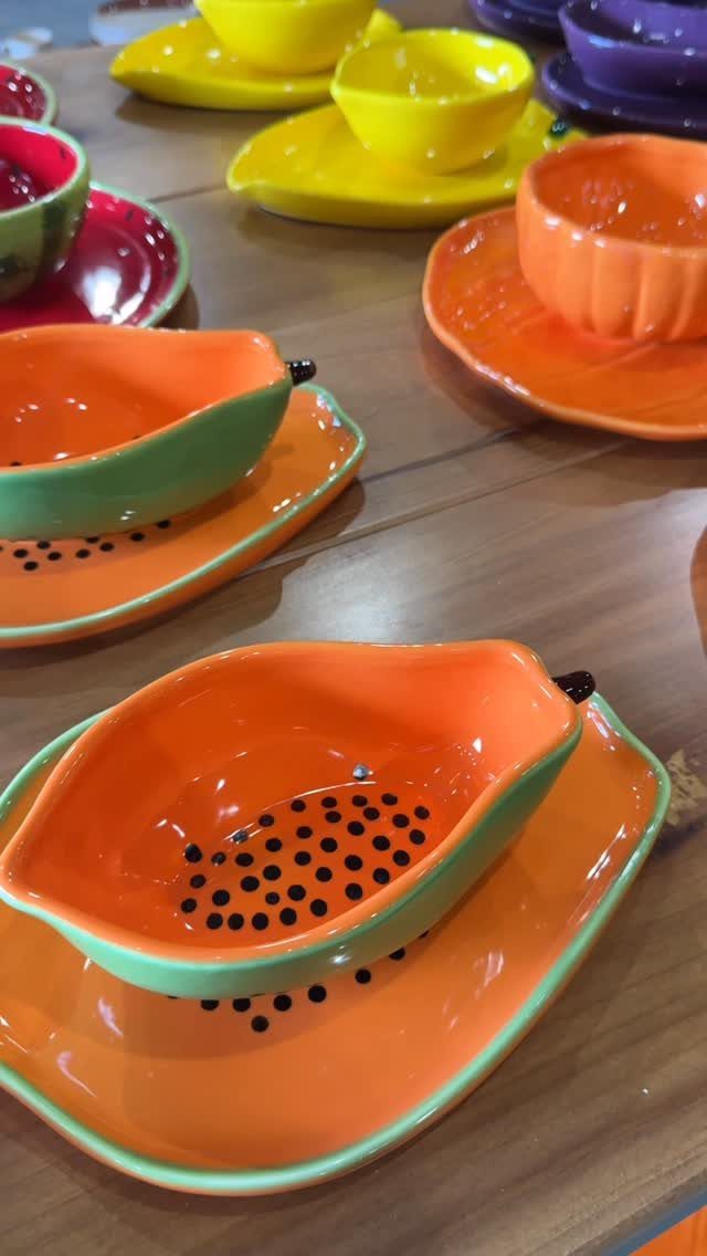 Fruit Shaped Plates in 12 Styles 10 Fruit shaped ceramic plates and bowls in orange, green, and yellow on wood.