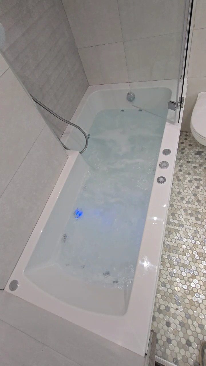 Bathroom Alcove Ideas: 29 Designs for Tubs, Showers & More 14 White alcove bathtub with bubbling hydrotherapy jets and blue underwater lighting in a tiled bathroom.