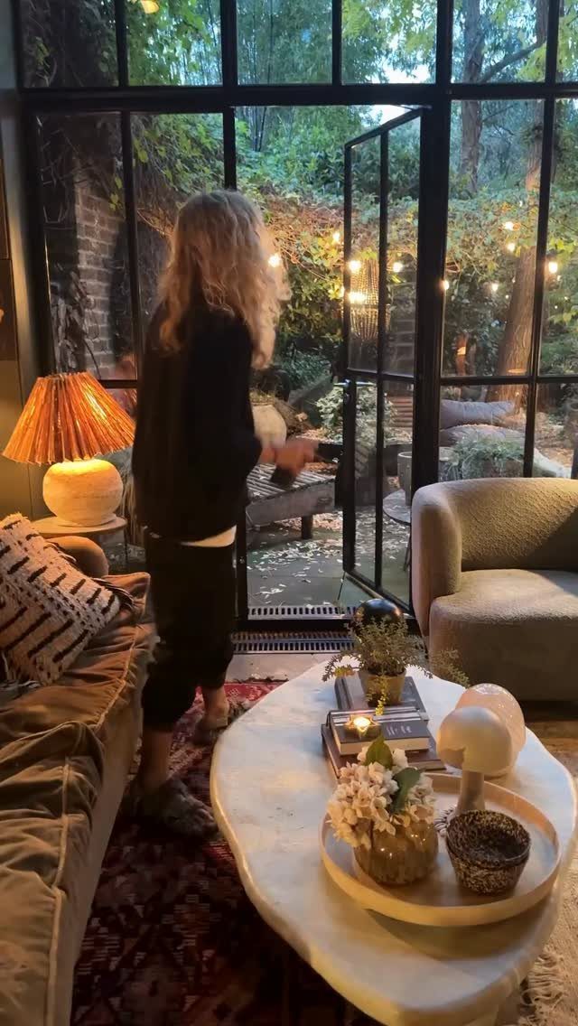 27 Vibey Living Room Aesthetic Ideas Worth Copying 25 Cozy living room with soft lighting, a white coffee table, and garden views.