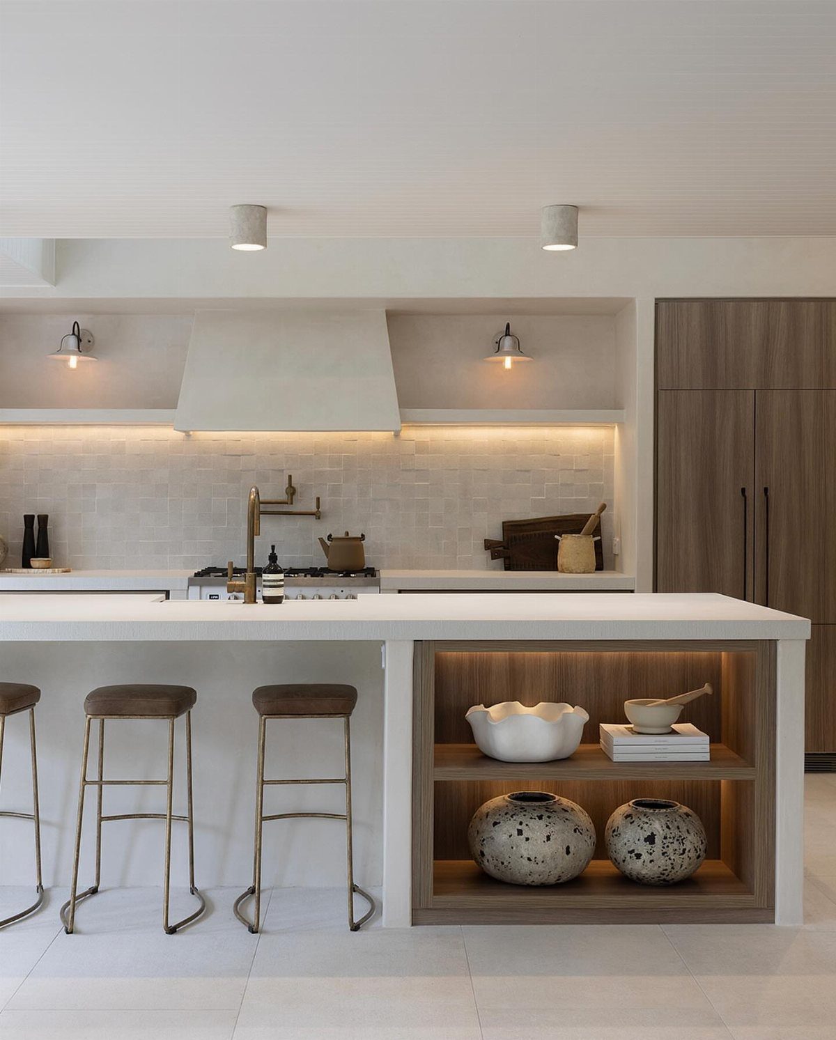 27 Small Kitchen with Fridge Ideas That Maximize Every Inch 3 Modern kitchen with white island and integrated wood-paneled refrigeration cabinetry.