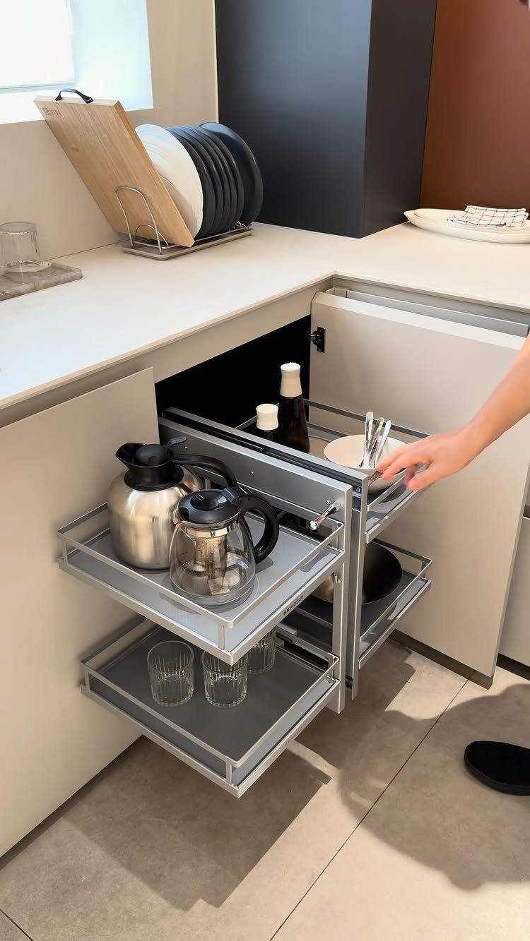 26 Pull Out Drawer Kitchen Ideas That Save Space 10 L-shaped metal pull-out corner cabinet organizer holding coffee pots and glassware in kitchen.