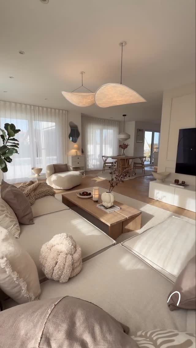 27 Vibey Living Room Aesthetic Ideas Worth Copying 9 Beige sectional sofa with neutral pillows and a wooden coffee table in a bright room.