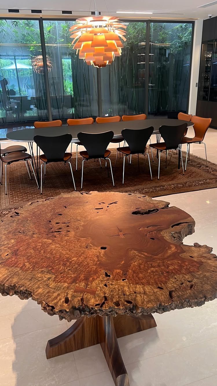 Contemporary Dining Sets in 12 Styles for Your Space 9 Live-edge wooden dining table with a glossy finish and sculptural base in a showroom.