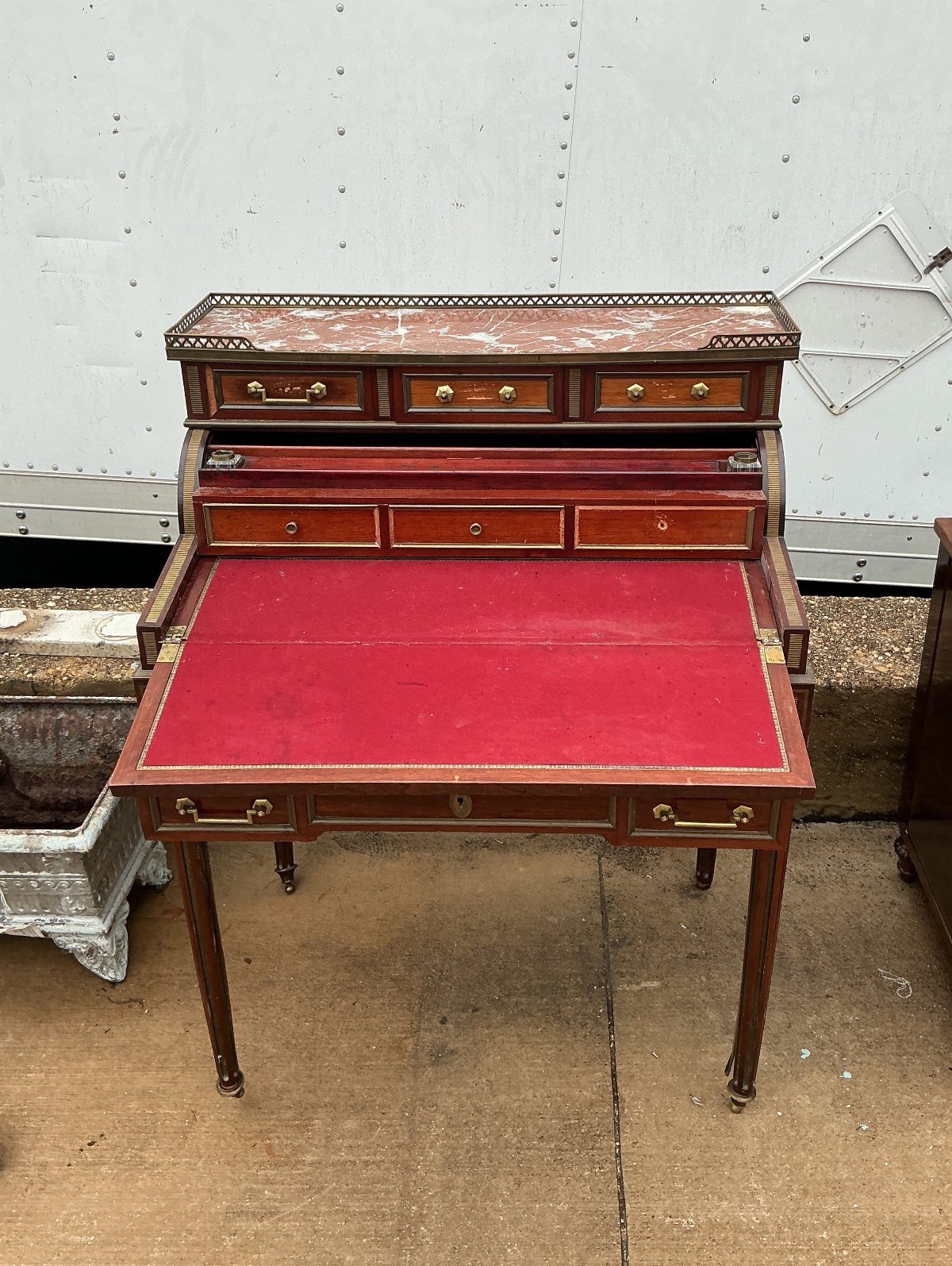 Vintage Louis XVI style secretary desk with red writing surface and tapered legs.