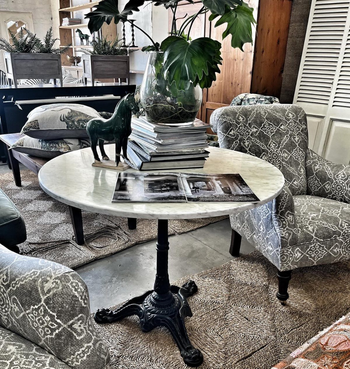 20 French Farmhouse Dining Table Ideas for Every Style 2 Round white marble bistro table with ornate black iron base and decorative objects.