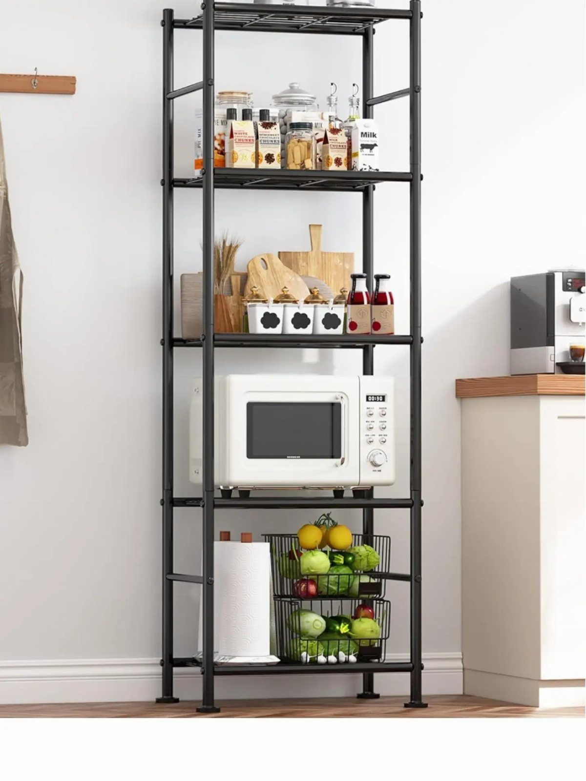 Black metal open shelving unit holding a white microwave and various kitchen supplies.