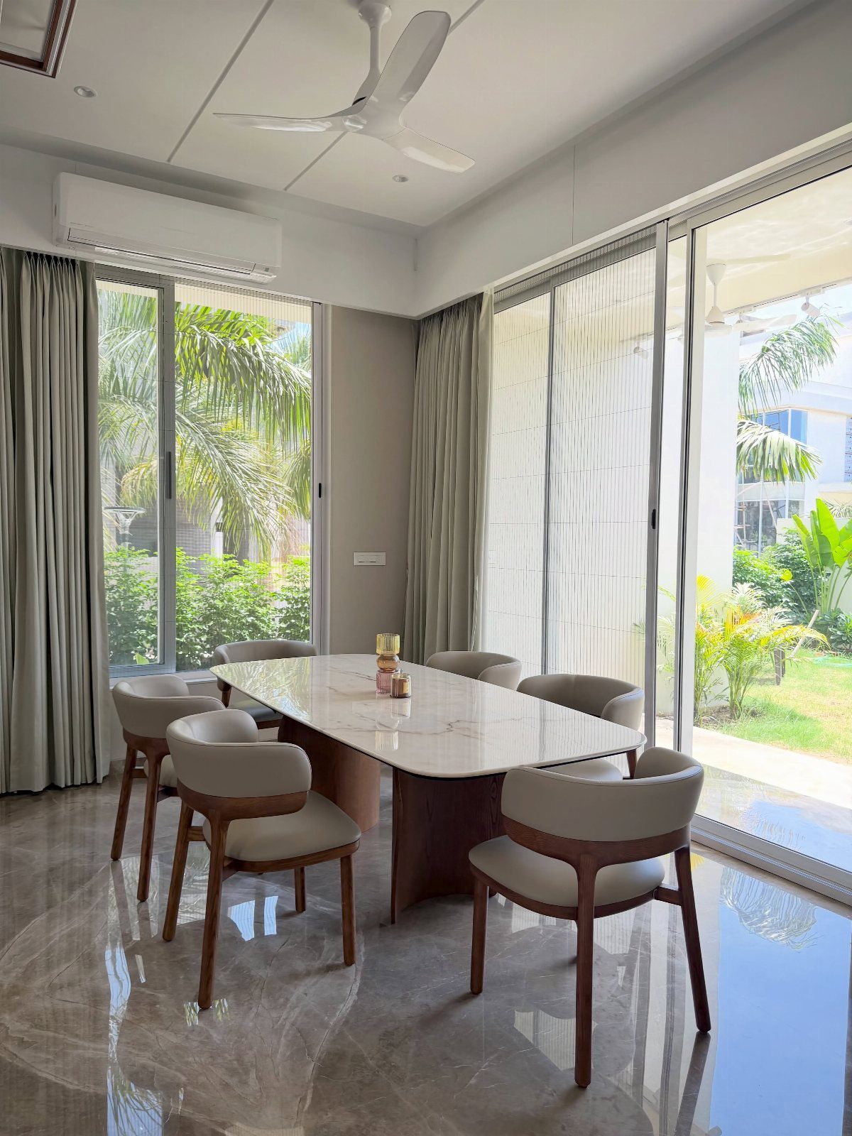 Contemporary Dining Sets in 12 Styles for Your Space 8 White marble dining table with curved beige chairs in a bright, modern room.