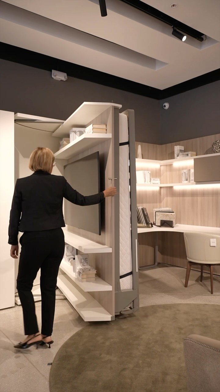 12 Space Saving Furniture Ideas That Actually Work 3 Murphy bed unit with a television and shelves, being operated by a woman.