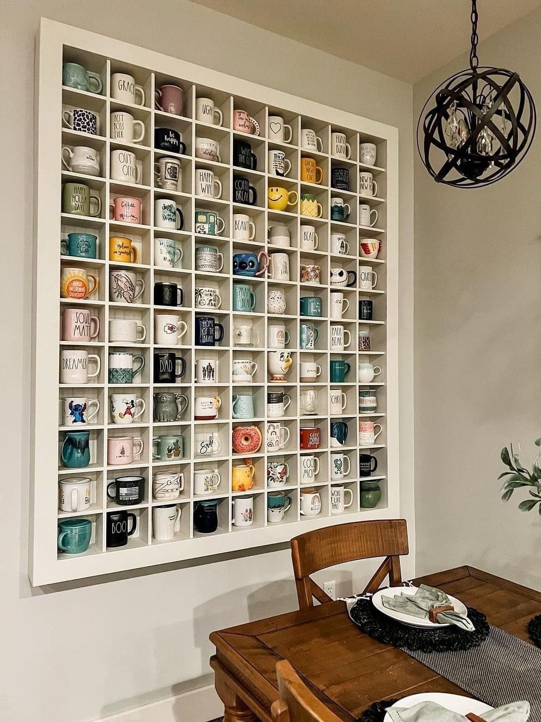 White grid wall shelf displaying a large collection of colorful ceramic coffee mugs.