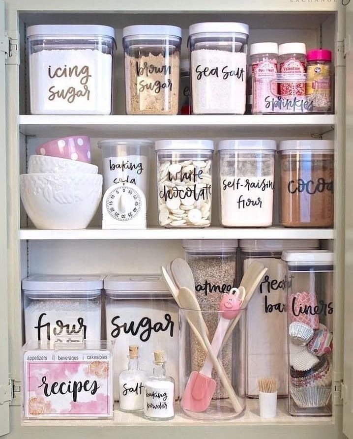 10 Kitchen Storage Container Ideas for Pantry and Fridge 11 Clear plastic baking containers with labels organized on a white pantry shelf.