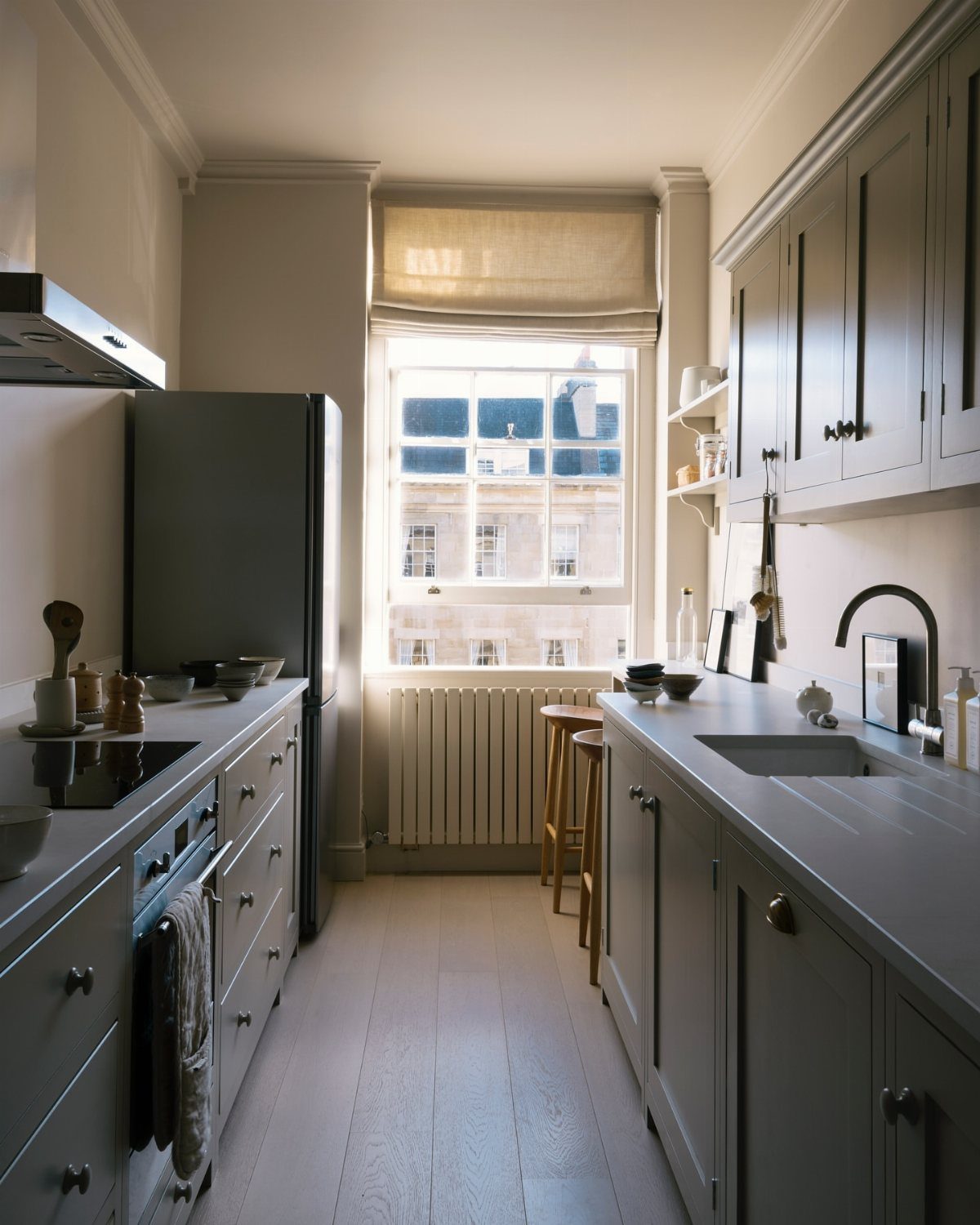 32 Simply Kitchen Design Ideas for a Clean, Modern Space 9 Parallel grey kitchen counters and cabinets in a narrow galley layout with light flooring.