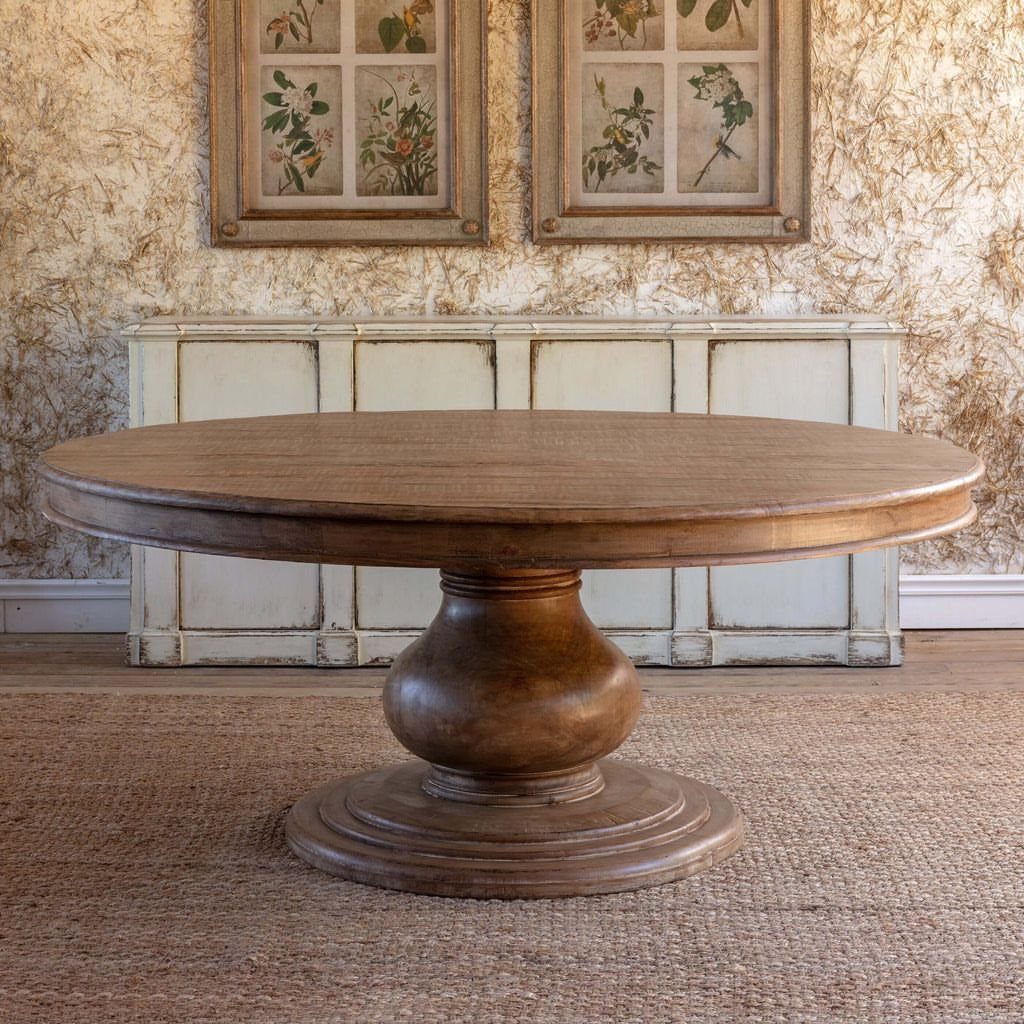 20 French Farmhouse Dining Table Ideas for Every Style 4 Round wooden dining table with a carved pedestal base in a rustic room.
