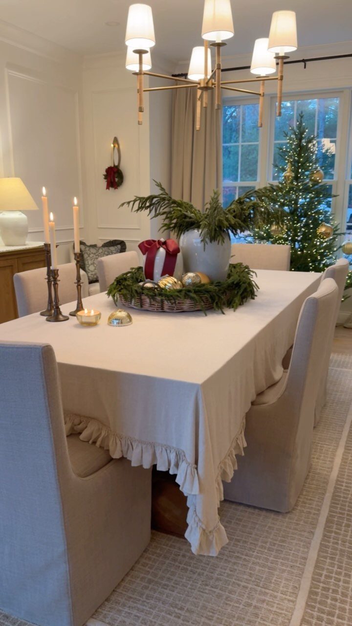 Cream-colored ruffled tablecloth on a dining table with a festive holiday centerpiece.