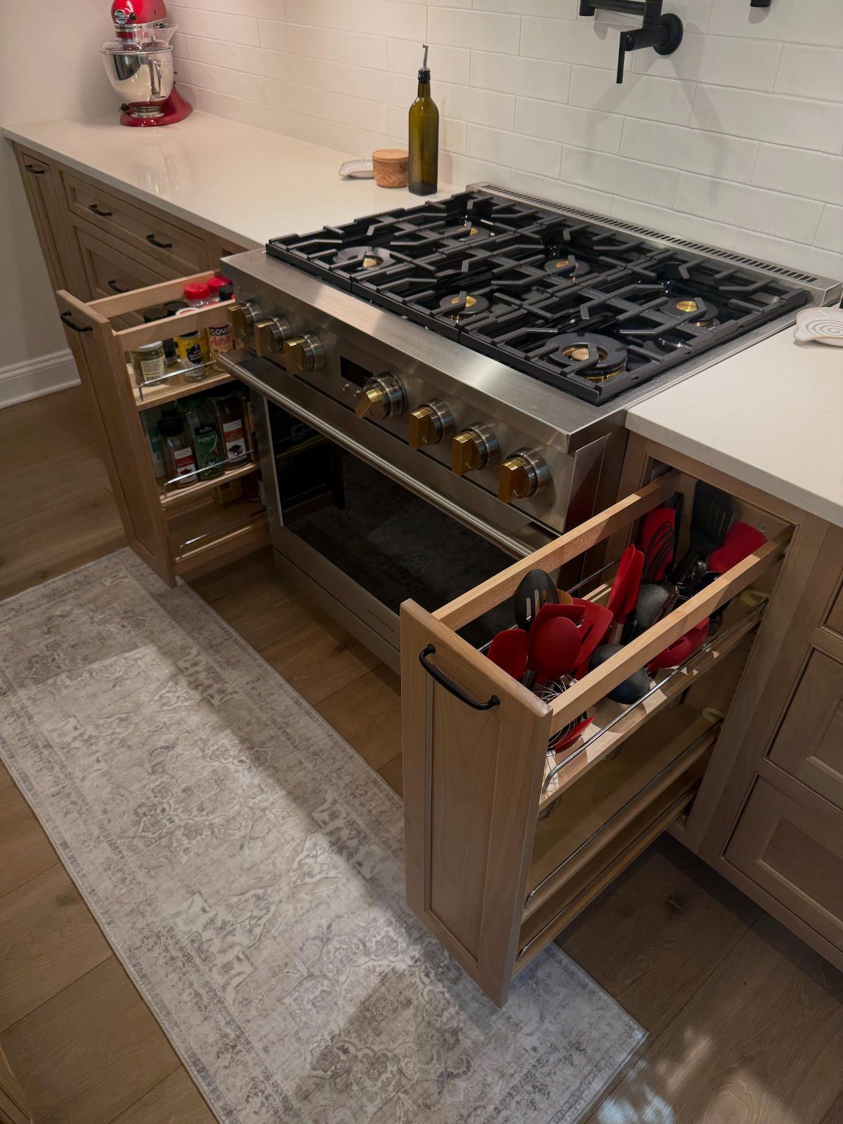 32 Simply Kitchen Design Ideas for a Clean, Modern Space 29 Two narrow pull-out pantry shelves extended from light wood cabinets next to a gas range.