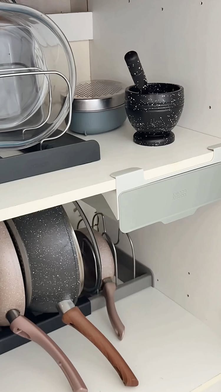 27 Small Kitchen with Fridge Ideas That Maximize Every Inch 14 Kitchen cabinet with a pull-out sliding shelf and vertical pan organizer for storage.