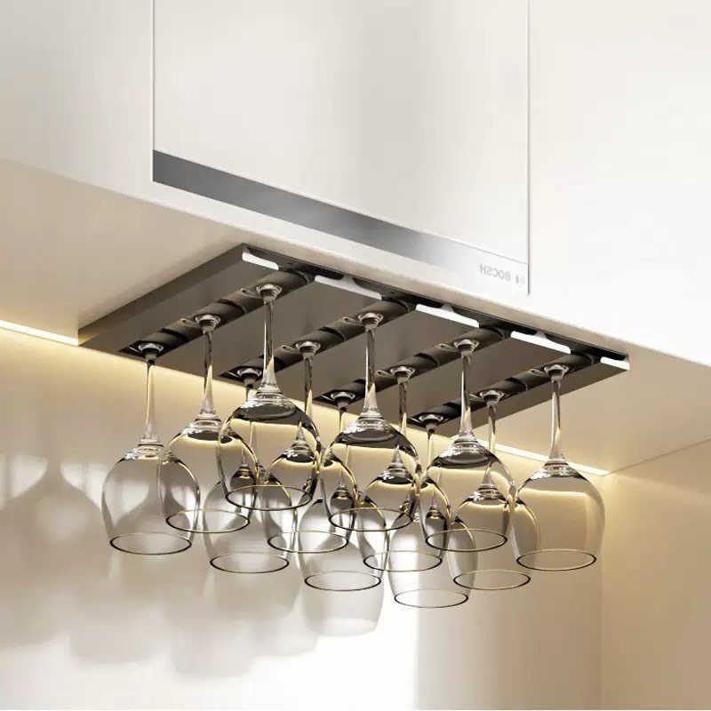 Stemware rack mounted under a white cabinet holding several clear wine glasses upside down.
