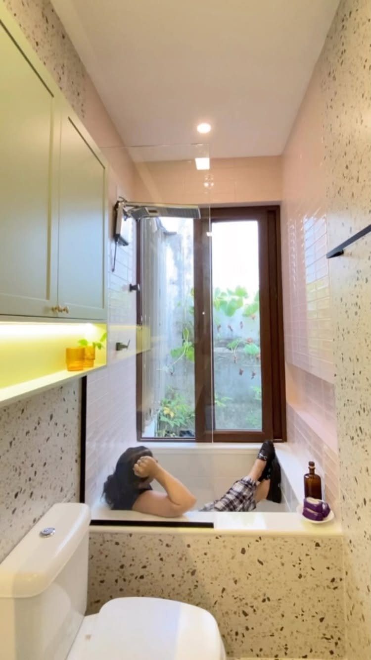 Bathroom Alcove Ideas: 29 Designs for Tubs, Showers & More 30 White bathtub installed in a narrow bathroom alcove with terrazzo walls and cabinetry.