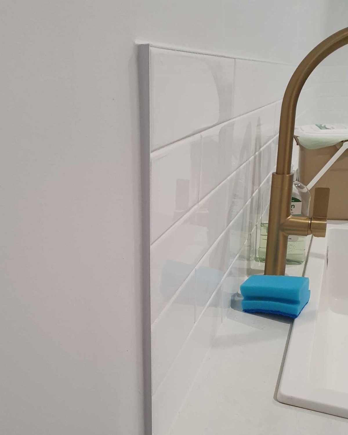 Bathroom Alcove Ideas: 29 Designs for Tubs, Showers & More 13 White subway tiles with a vertical white tile trim piece and gold faucet.