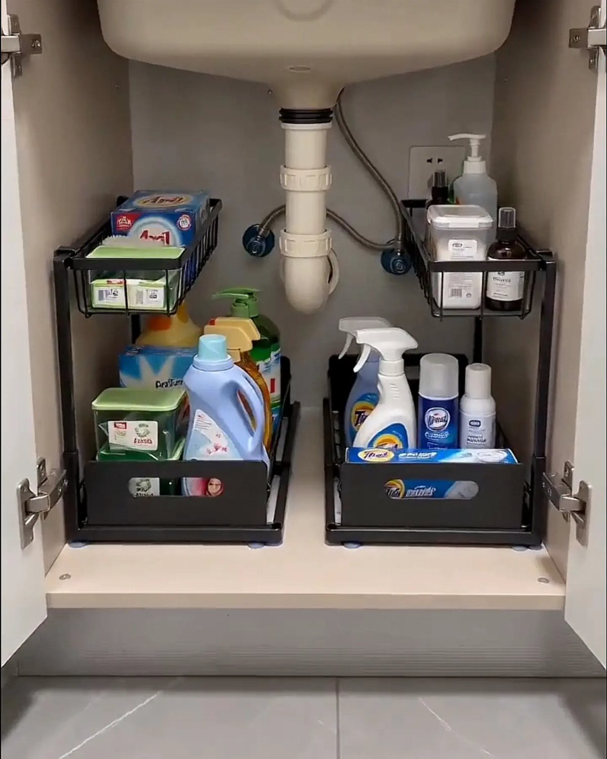 26 Pull Out Drawer Kitchen Ideas That Save Space 16 Black pull-out sliding organizers under a kitchen sink holding various cleaning supplies.