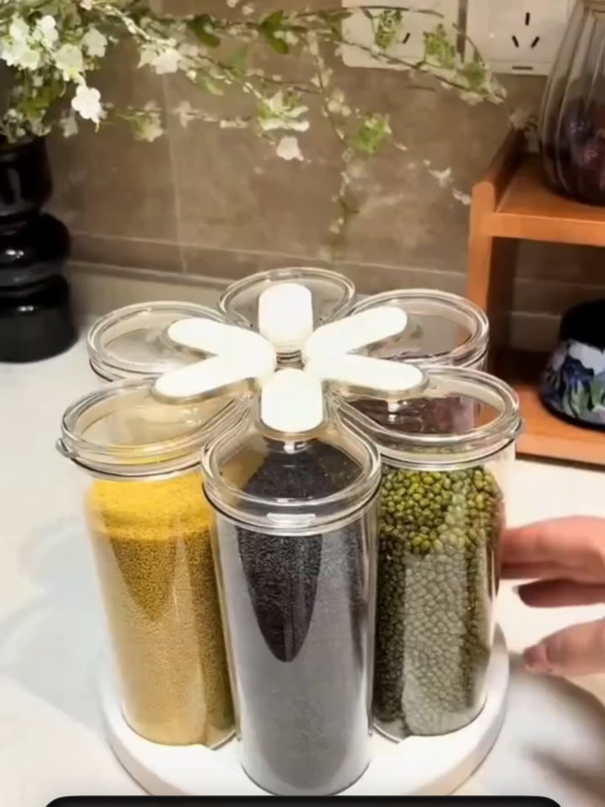 Rotating kitchen carousel with six glass jars filled with various colorful grains and seeds.