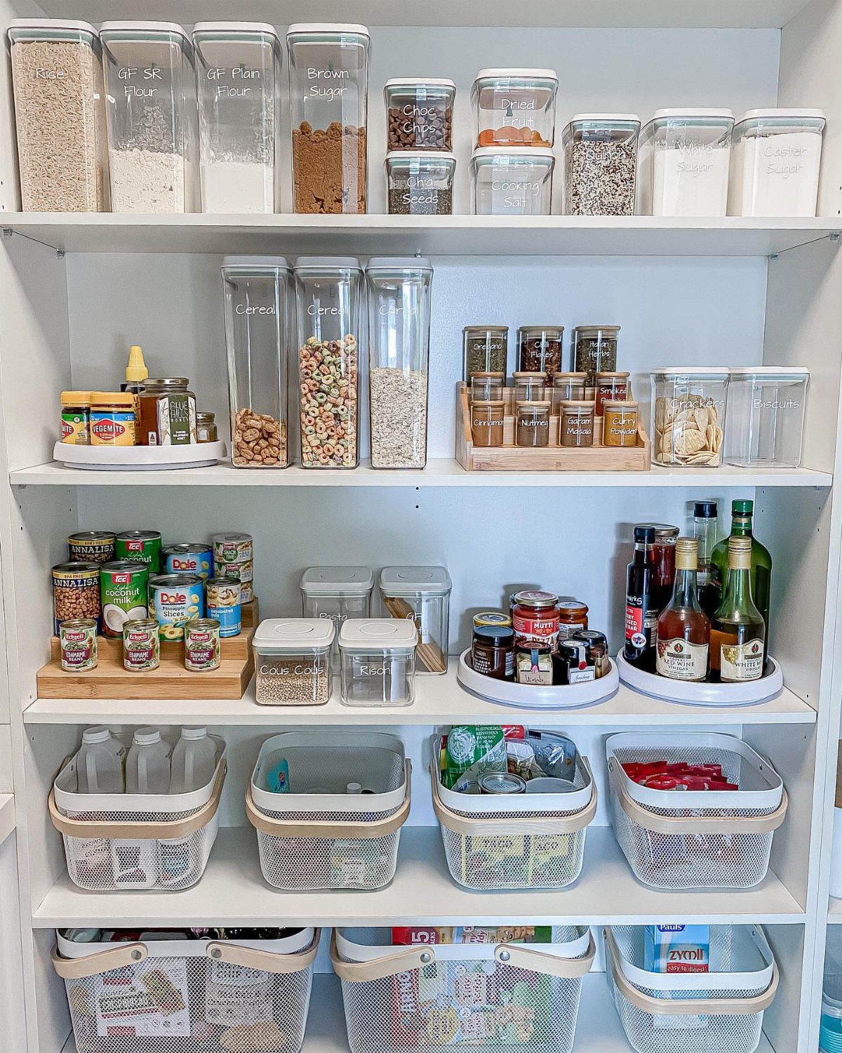 10 Kitchen Storage Container Ideas for Pantry and Fridge 2 Organized white pantry shelves with clear airtight food containers and woven storage baskets.