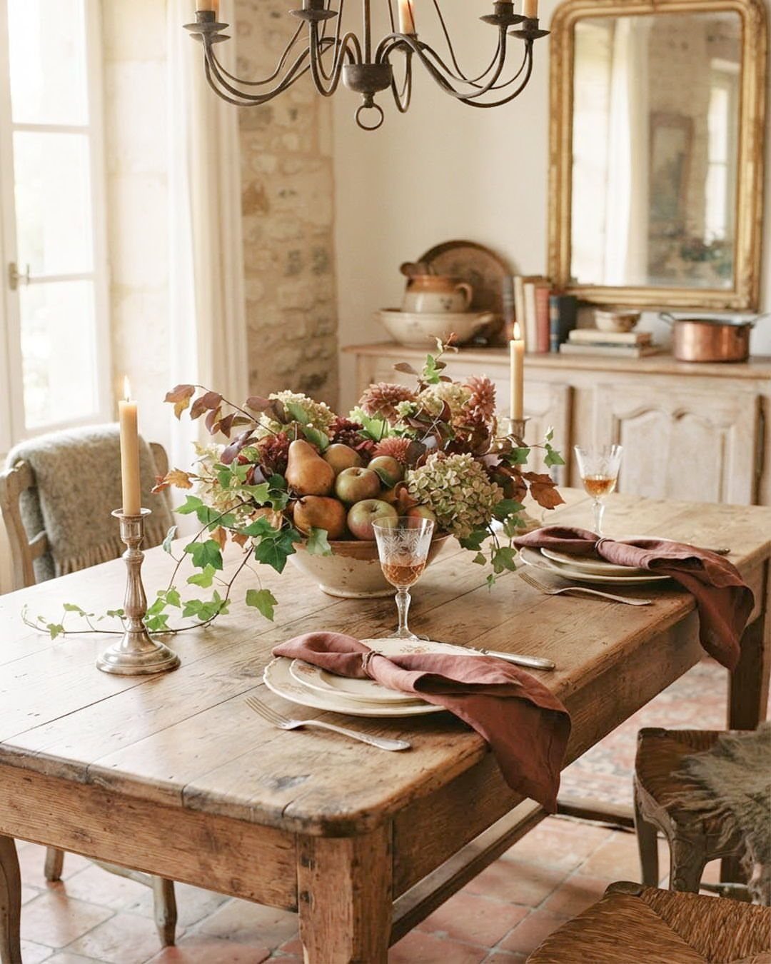 20 French Farmhouse Dining Table Ideas for Every Style 7 Rustic wooden harvest table with autumn fruit centerpiece and candlelit place settings
