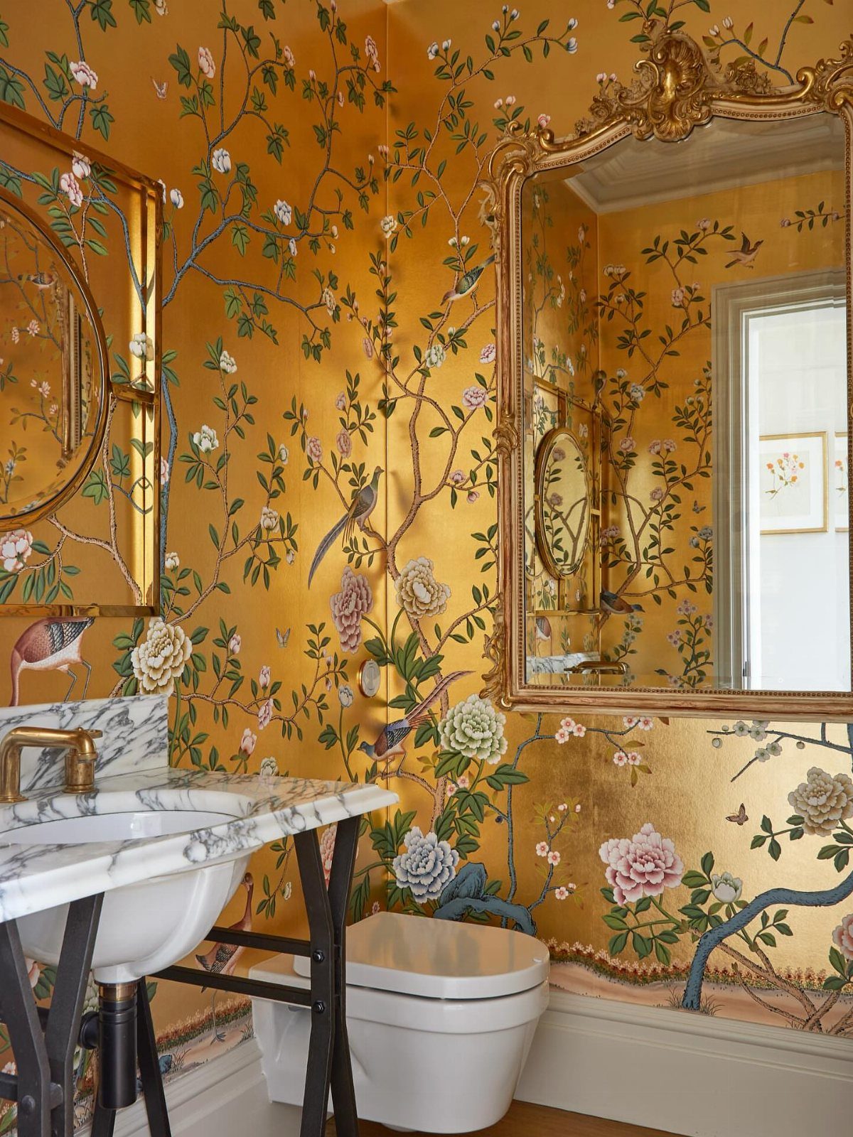 Bathroom Alcove Ideas: 29 Designs for Tubs, Showers & More 21 Gold floral wallpaper in a small bathroom alcove with a white toilet and marble sink.